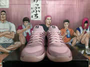 Front view of pink Nike basketball sneakers with black tongue details and pale soles on a shoe box.