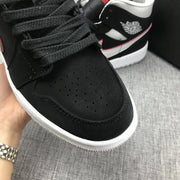 Close-up of the perforated black toe box and black laces.