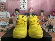 Front view of the pair showing yellow laces, perforated toe panels, and black tongue logos.