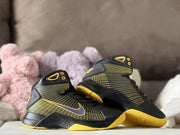 Angled product view highlighting the black high-top design, yellow accents, and patterned side panels.