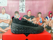 Side profile of a black Nike sneaker with angular detailing and a small red accent.