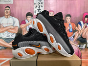 Angled view of two black Nike sneakers displaying the patterned side panels and orange outsole inserts.