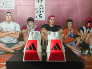Rear view of the white running shoes showing bright red heel panels and black adidas logos.