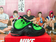 Side view of a black and bright green Nike Air Penny II sneaker