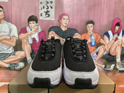 Front view of the pair showing black laces, black uppers, white toe overlays, and black toe caps.