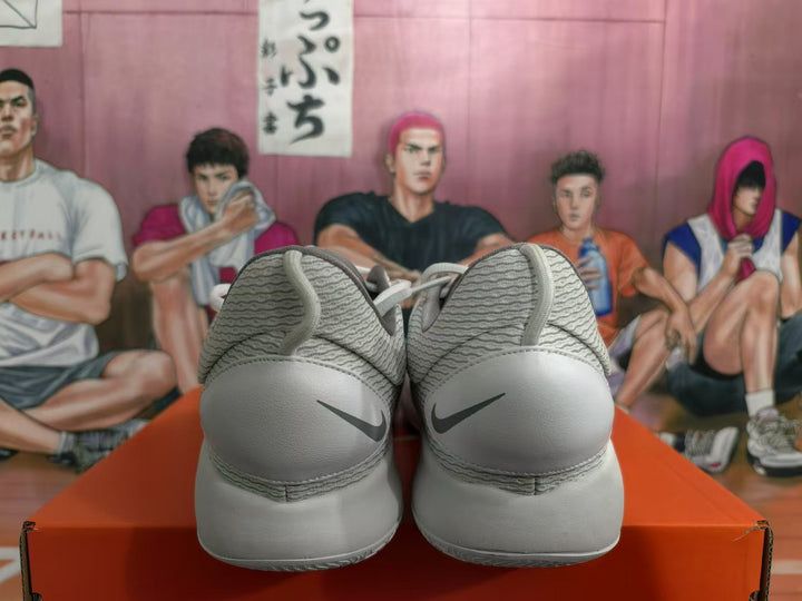 Rear view of a white Nike sneaker pair showing textured collars, heel panels, and dark Swoosh logos.