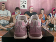 Rear view of the pink Nike sneakers showing padded heel collars, heel panels and light-colored outsoles.