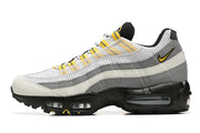 Side profile of a Nike Air Max 95 TT sneaker with layered grey and white panels and a black sole.