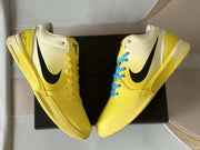 Overhead view of the pair showing the black Swooshes, yellow laces, and perforated toe panels.