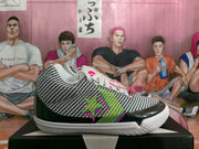 Side profile of a Converse sneaker showing the patterned upper, multicolor star detail, black toe overlay, and white sole.