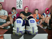 Rear view of the paired sneakers showing purple heel branding, white heel panels, and translucent outsole sections.