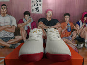 Front view of white Nike sneakers with white laces, textured uppers, and red outsoles.