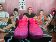 Front view of the pink Nike sneakers showing the laces, purple upper detailing, and padded collars.