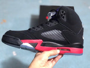 Side profile showing the black upper, perforated panel, red midsole, and visible air unit window.