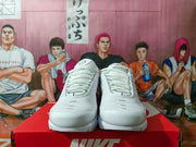 Front view of the white Nike sneakers showing the rounded toe boxes, lace systems and textured upper panels.