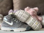 Gray sneaker pair with one shoe tilted to reveal the light outsole and herringbone-style tread pattern.