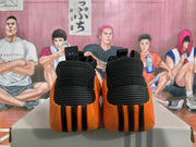 Rear view of black and orange basketball sneakers showing padded heels and sculpted outsole details