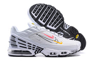 Side and outsole view of white Nike Air Max Plus sneakers with black geometric details and visible sole cushioning.