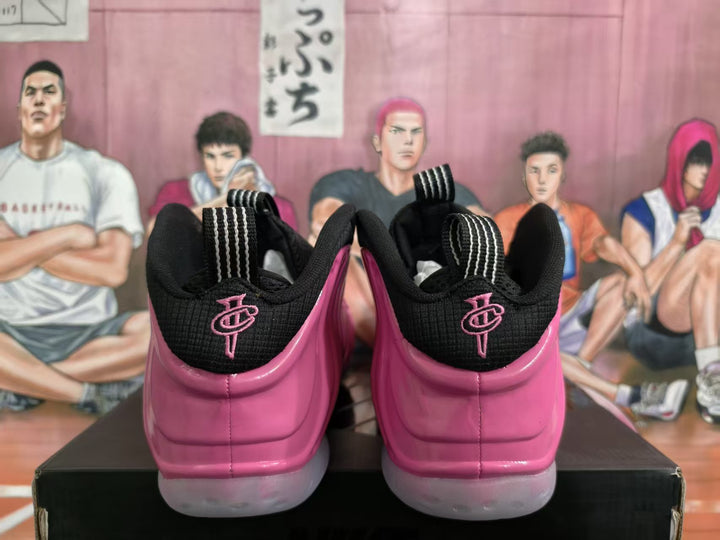 Rear view of pink and black high-top basketball shoes with heel embroidery and translucent-looking soles.