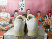 Rear view showing the heels and translucent-looking soles of off-white Nike shoes.
