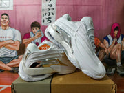 White sneaker side view showing sculpted panels and reflective silver-tone detailing