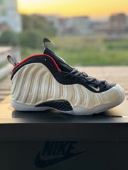 White high-top Foamposite-style sneaker with navy and red accents and a translucent outsole.