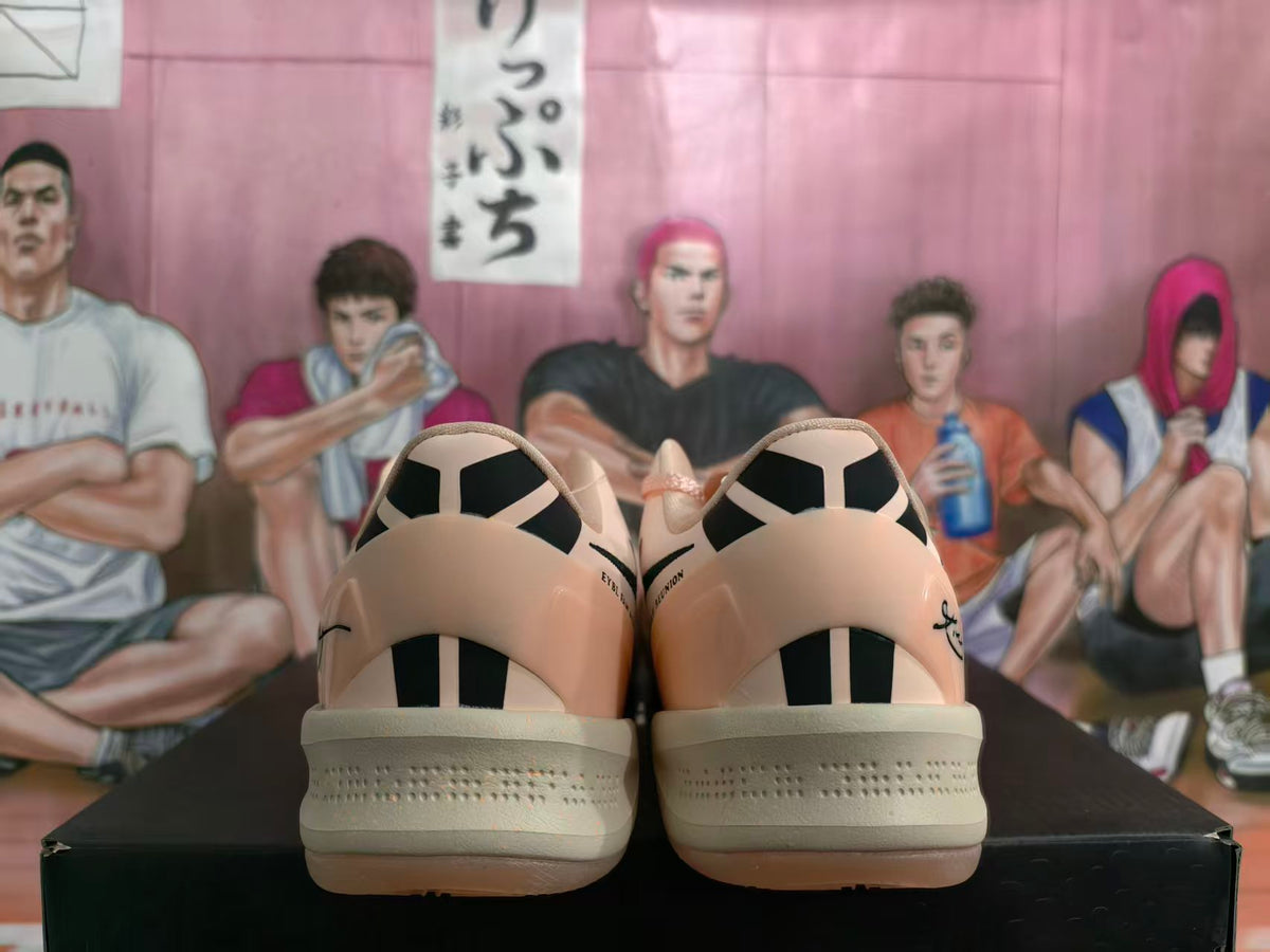Rear view of peach-colored basketball shoes with black heel details and light-colored soles.