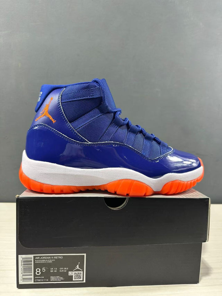 Blue and orange high-top Jordan sneaker displayed on a black shoebox; the box label visibly shows Air Jordan 11 Retro, EU 42, UK 7.5, and CM 26.5.
