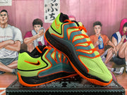 Angled view of the fluorescent green and orange Nike sneakers displayed one over the other on a patterned box.