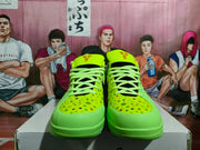 Front view of fluorescent green Nike basketball sneakers with pale green laces, black mesh tongues, and multicolor dotted toe boxes.