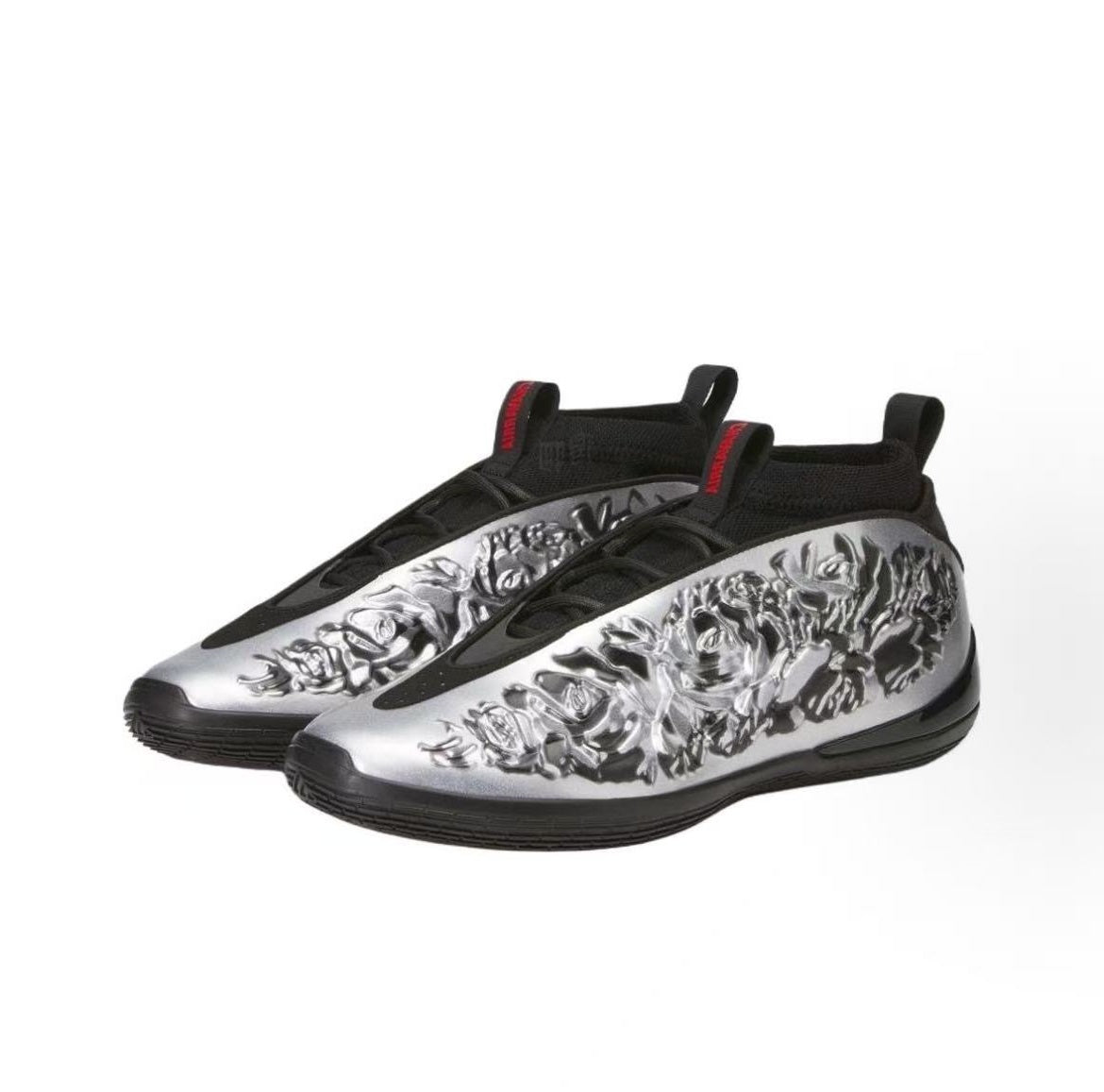 Pair of silver and black slip-on sneakers with textured silver uppers, black detailing, pull tabs, and black rubber outsoles.