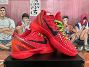 Angled view of paired red Nike basketball sneakers showing black Swooshes, green laces, textured uppers, and Zoom branding on the midsole.
