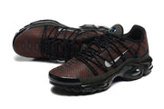 Top angled view of brown patterned Nike Air Max Plus sneakers with black laces and dark green overlays.