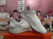 Angled view of two white Nike basketball sneakers showing the lace-up upper, padded collar, side branding, and outsole pattern.