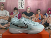 Side view of a blue Nike sneaker showing the black Swoosh, textured upper, lace-up closure, and white midsole.