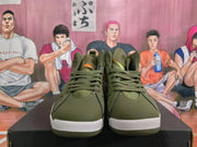 Front view of olive green Jordan high-top sneakers with orange accents and lace-up closure