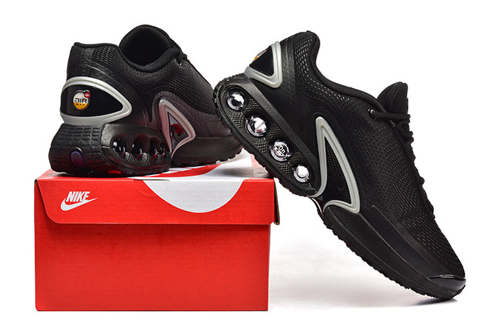 Black Nike sneakers displayed on a red shoe box, showing the side and heel