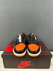 Front view of the pair showing black overlays, orange perforated toe panels and branded tongues.