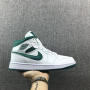 Side profile of a white and Mystic Green Jordan mid-top sneaker.