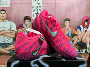Angled view of pink and purple Nike basketball sneakers showing the swoosh, textured upper, padded collar, and outsole.