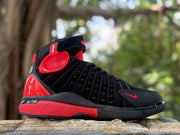 Opposite side view showing the black upper, red ankle panel, and red outsole accents.