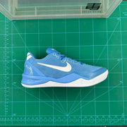 Side view of a blue and white basketball shoe on a measuring mat