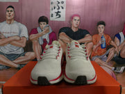 Front view showing the textured white uppers, red lace accents, and dark outsole sections.