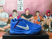 Side profile of a blue Nike Kobe shoe with a white swoosh and red stitch-like detailing.
