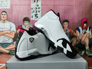 Pair of white and black high-top basketball sneakers displayed on a shoe box, showing the side panels, red accents, and black outsole.