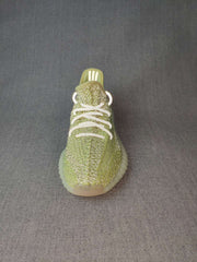 Front view of the green sneaker showing the white laces, textured upper, and ribbed sole edge.