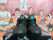 Front view of the black Nike basketball sneakers showing black laces, blue tongue graphics and textured toe boxes.