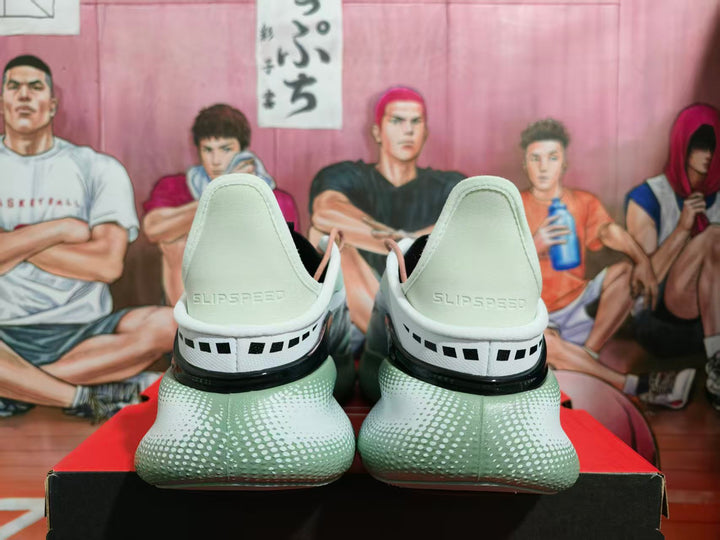 Rear view of white Under Armour HOVR sneakers with black heel accents and a green-tinted textured outsole.