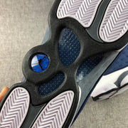 Close-up of the Air Jordan 13 Flint outsole with patterned tread and blue circular detail.