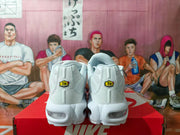 Rear view of the white Nike sneakers showing yellow and black TN Air heel badges and translucent heel cushioning windows.